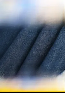 Macro shot of dark blue knit denim fabric showing textured twill and pilling resistance