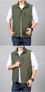 Detail of army green outdoor vest showing zip pockets and embroidered text decoration