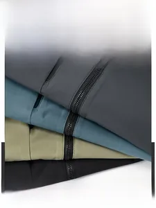 Detail showing stack of four waterproof windbreakers in grey blue green and black colors