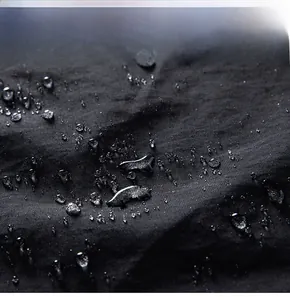 Close-up detail of high-tech waterproof fabric with water droplets on black windbreaker jacket