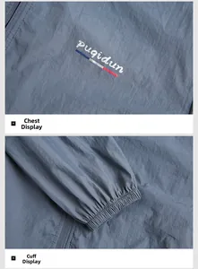 Detail view of the elastic cuffs and the logo design on this gray blue windbreaker