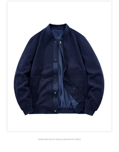 Dettaglio della giacca blu navy in tessuto a nido d'ape con bottoni a scatto in metallo