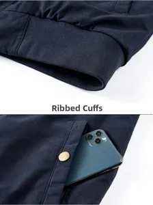 Detail of navy pilot jacket showing ribbed cuffs, deep side pocket, and metal snap button