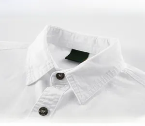 Détail d'une chemise blanche en coton avec col carré et finitions de coutures doublement piquées