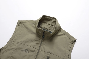 Detail of outdoor vest featuring embroidered logo and functional vertical zipper pocket