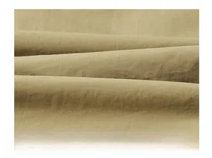 Gros plan du tissu de gilet kaki montrant une texture tissée fine et un matériau durable