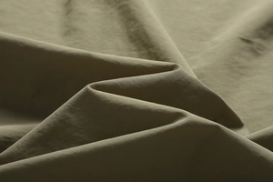 Detailed macro shot of durable olive green high-density twill fabric for outdoor vest