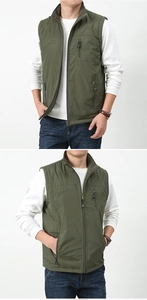 Detail view of olive green reversible outdoor vest with zip pockets and stand-up collar
