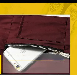 Detail of burgundy casual jacket showing a metal zippered pocket holding a smartphone