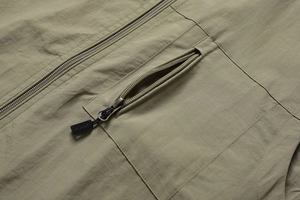 Detailed macro view of khaki green outdoor vest with sports zipper and nylon texture