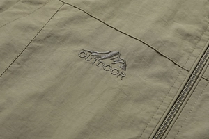 Detail of embroidered Outdoor logo and mountain graphic on army green tactical vest