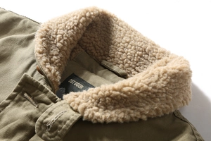 Close-up of military green jacket collar featuring thick beige fleece lining and woven label