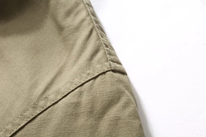 Detail of double-needle stitching and khaki corduroy fabric on men's winter jacket shoulder