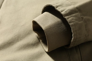 Detailed macro view of khaki jacket sleeve with ribbed windproof cuffs and durable stitching