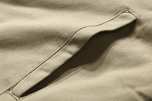 Close-up of khaki winter jacket welt pocket with reinforced stitching and twill fabric detail