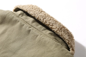 Close-up of olive green winter jacket with plush khaki lamb wool collar and sturdy seams