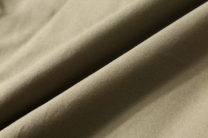 Macro detail of the olive green corduroy fabric showing thick woven texture and durability