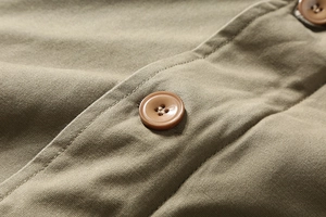Detail of khaki corduroy jacket showing high-quality stitching and a matching four-hole button