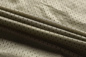 Detail of breathable olive mesh fabric with uniform ventilation holes for outdoor vests