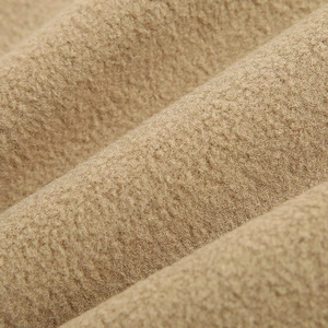 Close-up of camel fleece fabric on a reversible men's vest with soft curled texture