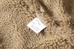 Detailed close-up of 100% cotton fabric and warm fleece lining on khaki jacket