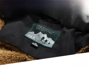 Detailaufnahme vom Winterjackenkragen mit braunem Teddyfutter und Militär-Etikett