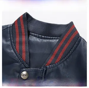 Dettaglio della giacca in pelle blu scuro con colletto baseball a righe e bottone