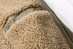Macro shot of fleece lining and durable military green fabric with metal zipper detail