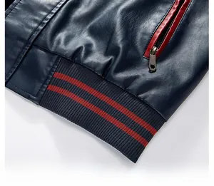 Dettaglio giacca in pelle blu navy con tasca a zip rossa e orlo a coste con strisce rosse