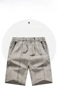 Detail of grey plaid cotton shorts featuring elastic waist, drawstring, and zip pockets