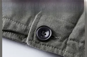 Gros plan sur le bouton à quatre trous et le tissu sergé texturé de la veste d'hiver