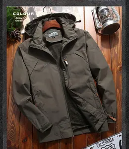 Detail of army green outdoor jacket with zipper and mountain logo on a rustic wooden table
