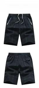 Detail of men's plaid cotton shorts featuring drawstring waist and reflective zip pocket