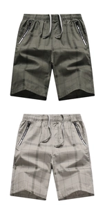 Detail of plaid men's cotton shorts showing elastic drawstring waist and side zipper pockets