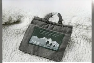 Détail de l'étiquette tissée grise avec logo de montagne sur doublure en laine d'agneau