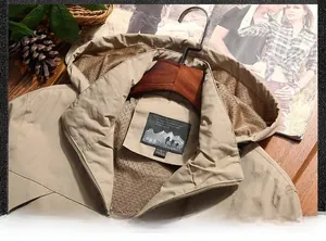 Close-up of khaki outdoor jacket collar with breathable mesh lining and size label