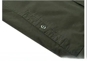 Close-up of army green cotton canvas jacket side pocket with silver metal snap button
