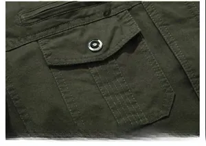Detailed close-up of military green cotton cargo jacket sleeve with metal snap pocket