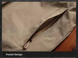 Detail of khaki outdoor jacket showing durable fabric and a hidden zipper pocket
