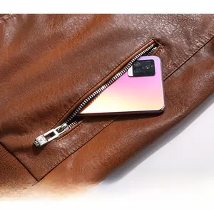 Detail of a brown leather jacket featuring a functional metal side zipper pocket for phone