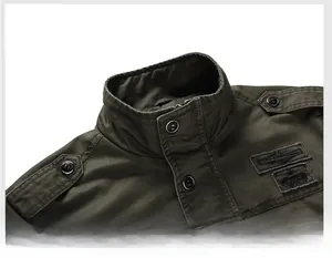 Detail of army green military jacket with stand collar, shoulder epaulettes and chest patch