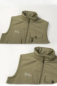 Detail of army green outdoor vest showing stand collar and FREEDOM chest print