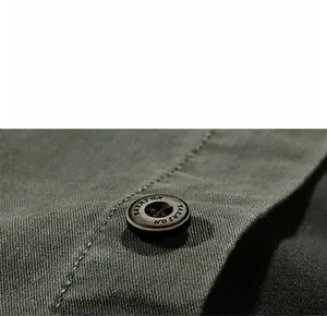 Detailed close-up of a durable fashion button on a green twill cotton work shirt