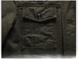 Close-up of military green cargo jacket featuring 3D pleated pocket and metal button