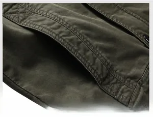 Macro view of the military green jacket side pocket with reinforced stitching details