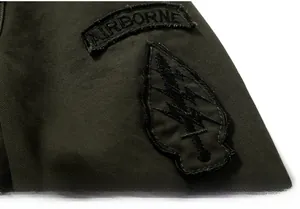 Primer plano del bordado Airborne y parche militar en la chaqueta de algodón verde