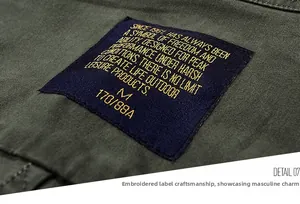 Detail of army green cotton shirt collar with navy embroidered label and gold size tag