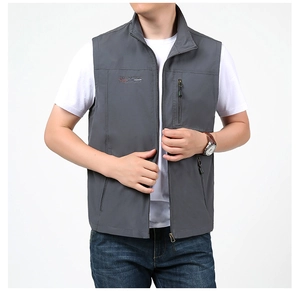 Détail du gilet extérieur gris avec col montant, broderie et poches zippées