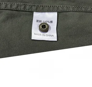 Macro detail of 100% cotton olive shirt with engraved button and laundry tag