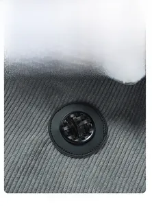 Detailansicht aus grauem Cordstoff mit Lammfell-Futter und einem runden Aufnäher-Detail